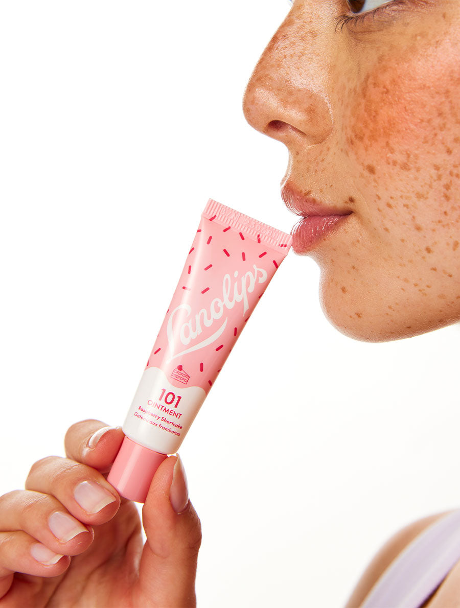 Model holding the Lanolips 101 Delicious - Raspberry Shortcake flavor.