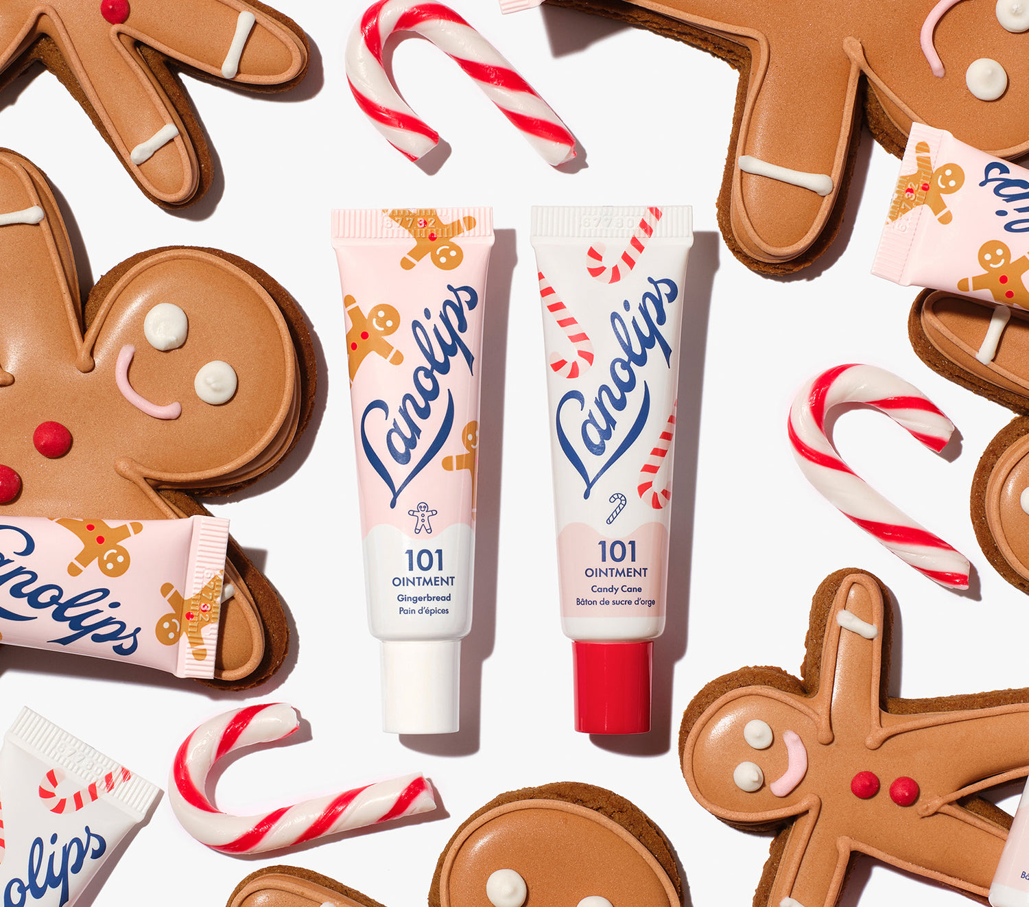 Lanolips 101 Ointment Multi-Balm Gingerbread & Candy Cane, styled with gingerbread cookies and candy canes, part of the limited-edition Holiday Gingerbread House Lip Duo. Enriched with lanolin, vitamin E and natural flavors for soft, hydrated lips.