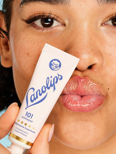 Model holding a tube of the Lanolips Original 101 Ointment - 15g. Voted the "World's Best Lip Balm". Using ultra-pure grade Aussie lanolin, our cult classic 101 Ointment offers a safer, more effective & 100% natural alternative to common petroleum-based balms.
