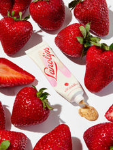 Squeezed tube shot of the Lanolips Lip Scrub Strawberry. A 100% natural balm based scrub that smooth and hydrates. | Load image into Gallery viewer, Squeezed tube of Lanolips Lip Scrub Strawberry. A 100% natural balm base scrub made with gentle sugar and real, finely ground strawberry seeds to smooth away dead skin.
