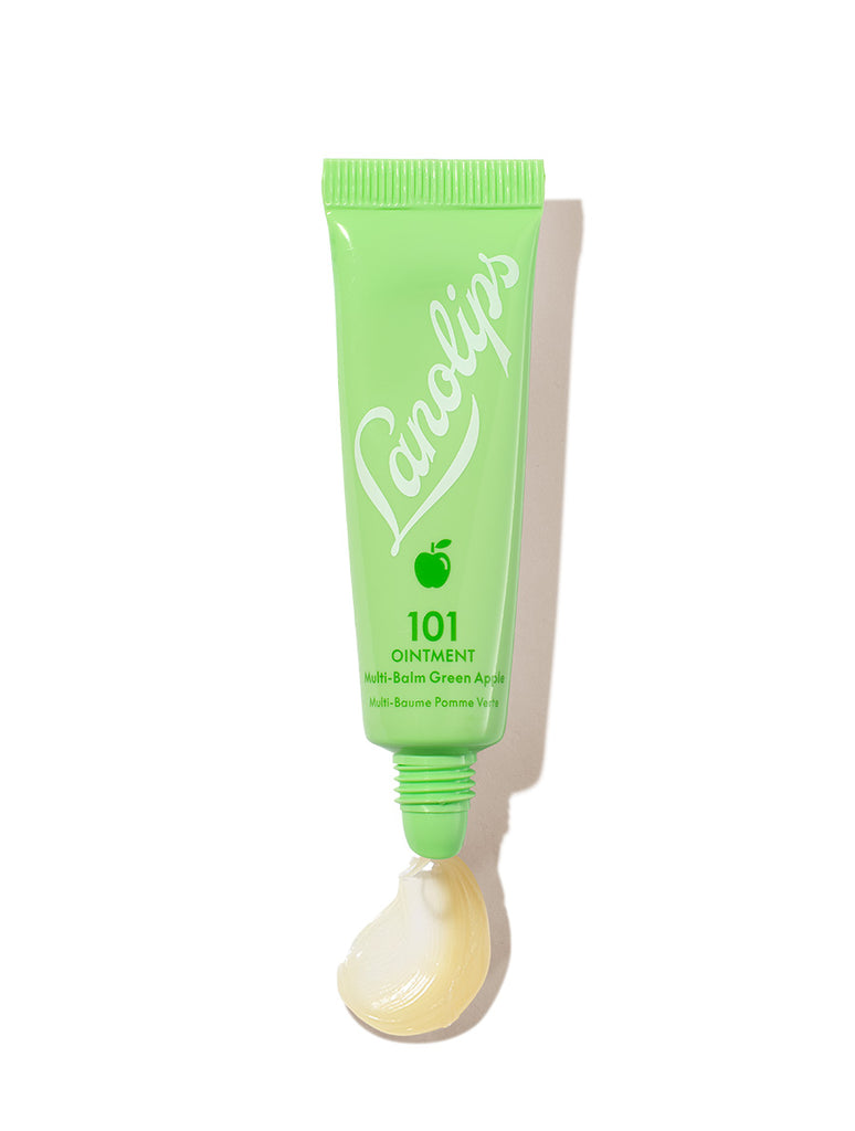 Lanolips 101 Ointment Multi-Balm Green Apple in a fresh green squeezable tube with a white cap. The packaging features the Lanolips logo in crisp white lettering and a small apple icon. A dollop of the rich, glossy balm is visible at the opening, showcasing its ultra-hydrating texture. Infused with lanolin and green apple extract, this balm provides deep moisture and a refreshing scent, perfect for soothing dry lips and skin.