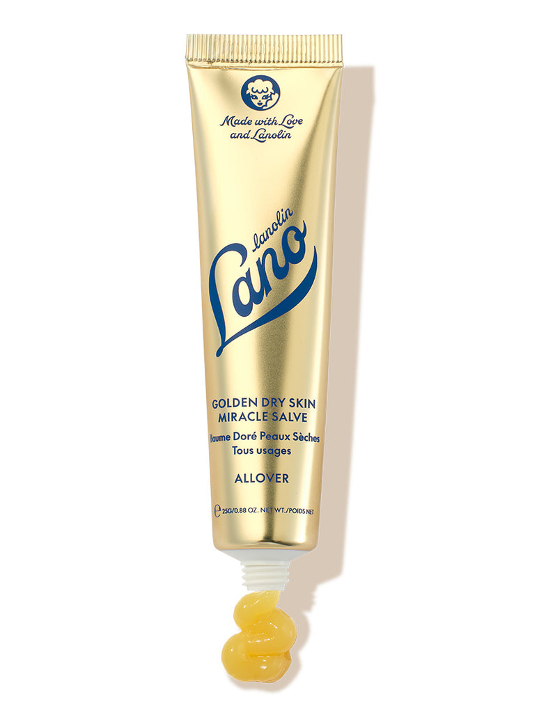 Lanolips Golden Dry Skin Miracle Salve in a metallic gold squeezable tube with a white cap. The packaging features the Lano logo in deep blue lettering, along with ‘Made with Love and Lanolin’ inscribed at the top. A small amount of the rich, golden balm is shown oozing from the tube, emphasizing its ultra-hydrating, multi-purpose formula designed to deeply nourish and repair very dry skin, hands, and rough patches.
