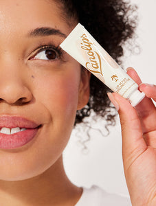 Model holding Lanolips Lip Scrub Coconutter. Our lip scrub is a conditioning lip scrub that is 100% natural.
