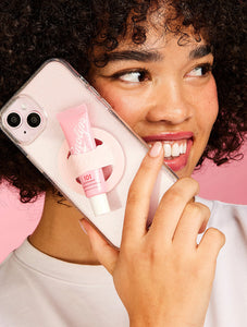 Model using the Lanolips Lip Balm Phone Holder holding the 101 Ointment Strawberry