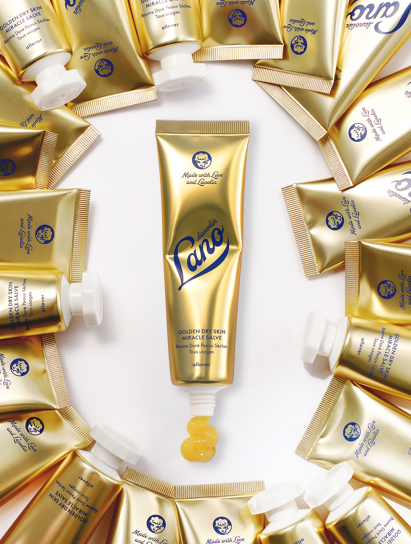 Product Shot of Lanolips Golden Dry Skin Miracle Salve 60g tube, surrounded with multiple closed tubes . An ultra-hydrating, multi-purpose formula designed to deeply nourish and repair very dry skin, hands, and rough patches.