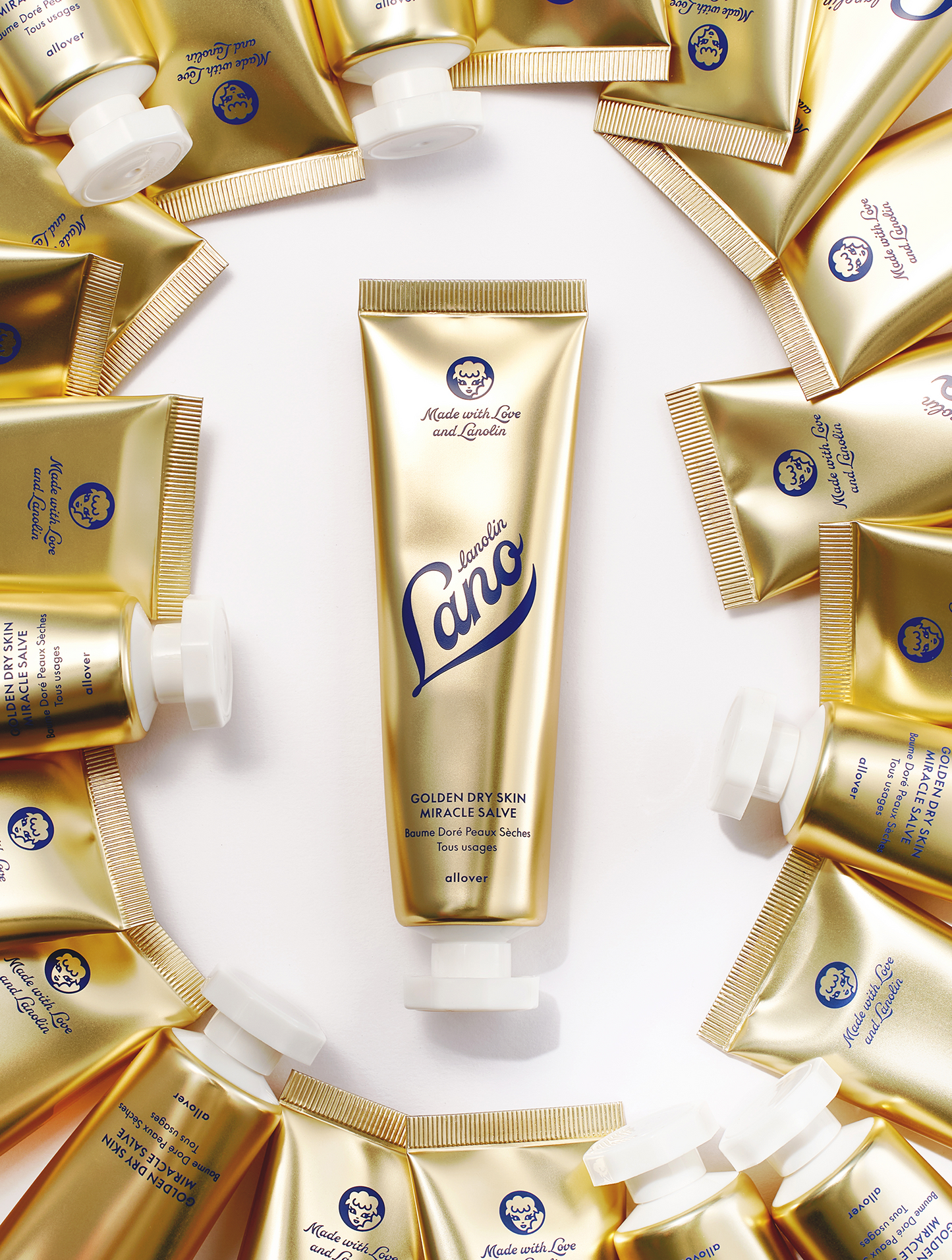 Product Shot of Lanolips Golden Dry Skin Miracle Salve 60g tube, surrounded with multiple closed tubes . An ultra-hydrating, multi-purpose formula designed to deeply nourish and repair very dry skin, hands, and rough patches.