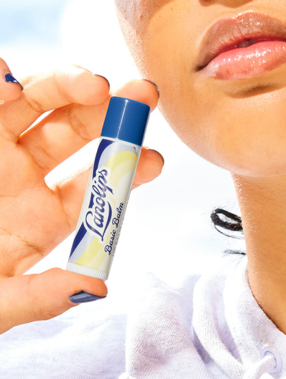 Model holding a tube on the Lanolips Basic Balm Original Vanilla against her face.