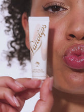 Squeezed tube shot of the Lanolips Lip Scrub Coconutter. A 100% natural balm based scrub that smooth and hydrates. | Load and play video in Gallery viewer, Video of Lanolips Lip Scrubs. Comes in two delicious flavors: Coconutter and Strawberry.
