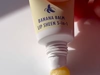 Lanolips Banana Balm + Lemonaid Lip Treatment | Load and play video in Gallery viewer, Video of Lanolips Banana Balm Lip Sheen 3-in-1 being squeezed from the tube
