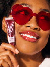 Lanolips' Glossy Balm Berry squeezed | Load image into Gallery viewer, Model wearing Lanolips&#39; Glossy Balm Berry.
