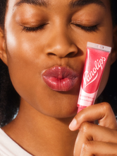 Lanolips' Glossy Balm in Candy Squeezed | Load image into Gallery viewer, Model holding Lanolips&#39; Glossy Balm Candy
